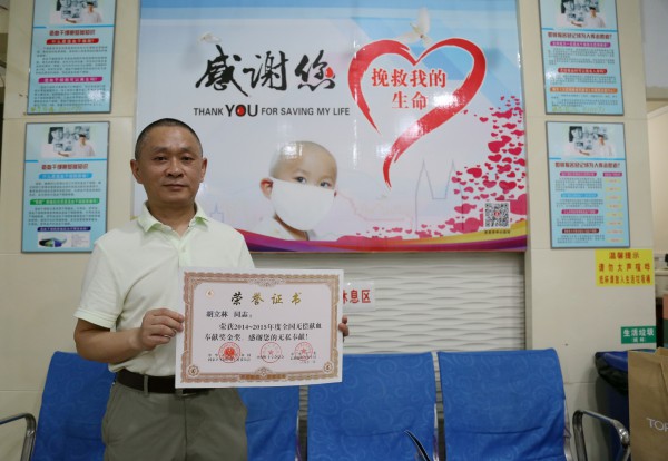 胡立林在爱心献血屋展示荣誉证书.jpg