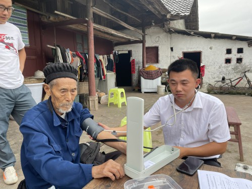 刘泰（右）给村里老人测血压 筠连县委宣传部供图.jpg