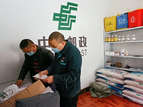 王场村王场邮政所代办员张国伦便和文师傅一起拆开邮件，一件、两件......的清点、交接.jpg